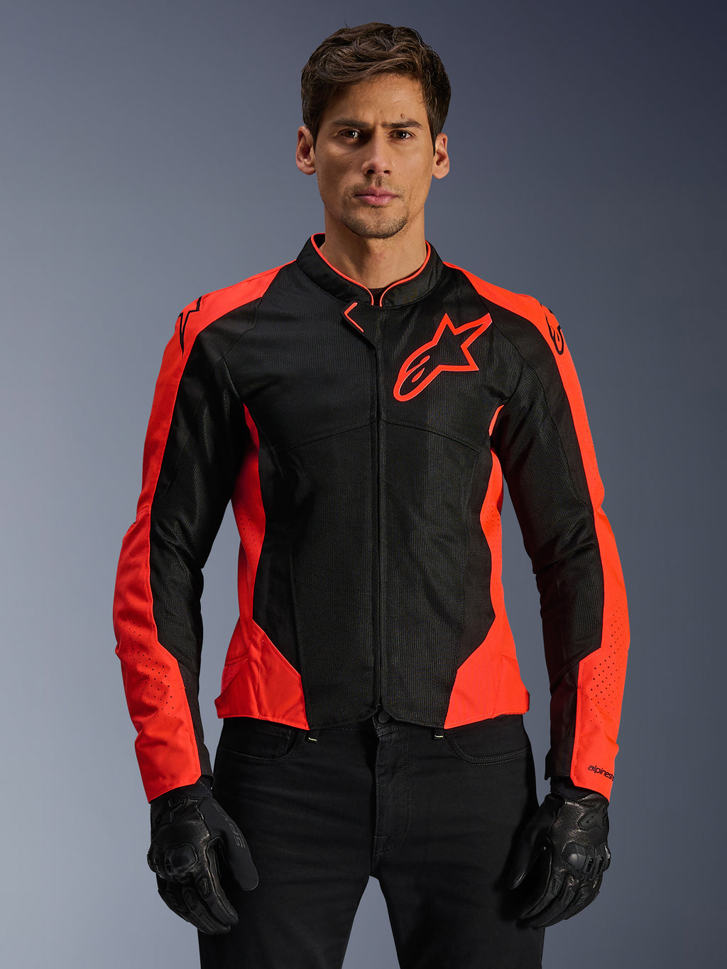 Veste Alpinestars Viper Air V4, veste de moto, rouge fluo et noir, portée par un mannequin avec des gants noirs, panneaux en mesh technique pour la ventilation, design sportif avec logo étoile Alpinestars sur la poitrine