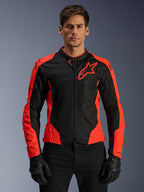 Veste Alpinestars Viper Air V4, veste de moto, rouge fluo et noir, portée par un mannequin avec des gants noirs, panneaux en mesh technique pour la ventilation, design sportif avec logo étoile Alpinestars sur la poitrine