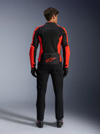 Veste Alpinestars Viper Air V4, rouge fluo et noir, vue de dos montrant de larges panneaux en maille technique et des accents latéraux rouge fluo, logo Alpinestars rouge dans le bas du dos, portée avec un pantalon de moto et des gants noirs