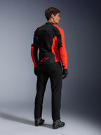 Veste Alpinestars Viper Air V4, Rouge Fluo Noir, vue arrière sur mannequin, présentant des panneaux en maille technique et un logo étoile rouge en bas du dos, associée à un pantalon et des gants de moto noirs pour un look de route complet.