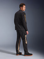 Alpinestars Dice Jacket, Urban Motorcycle Jacket, Black, 3/4 rear view on model, featuring vintage field jacket aesthetic with gold Alpinestars logo on sleeve, worn with coordinating black and tan riding pants and black sneakers