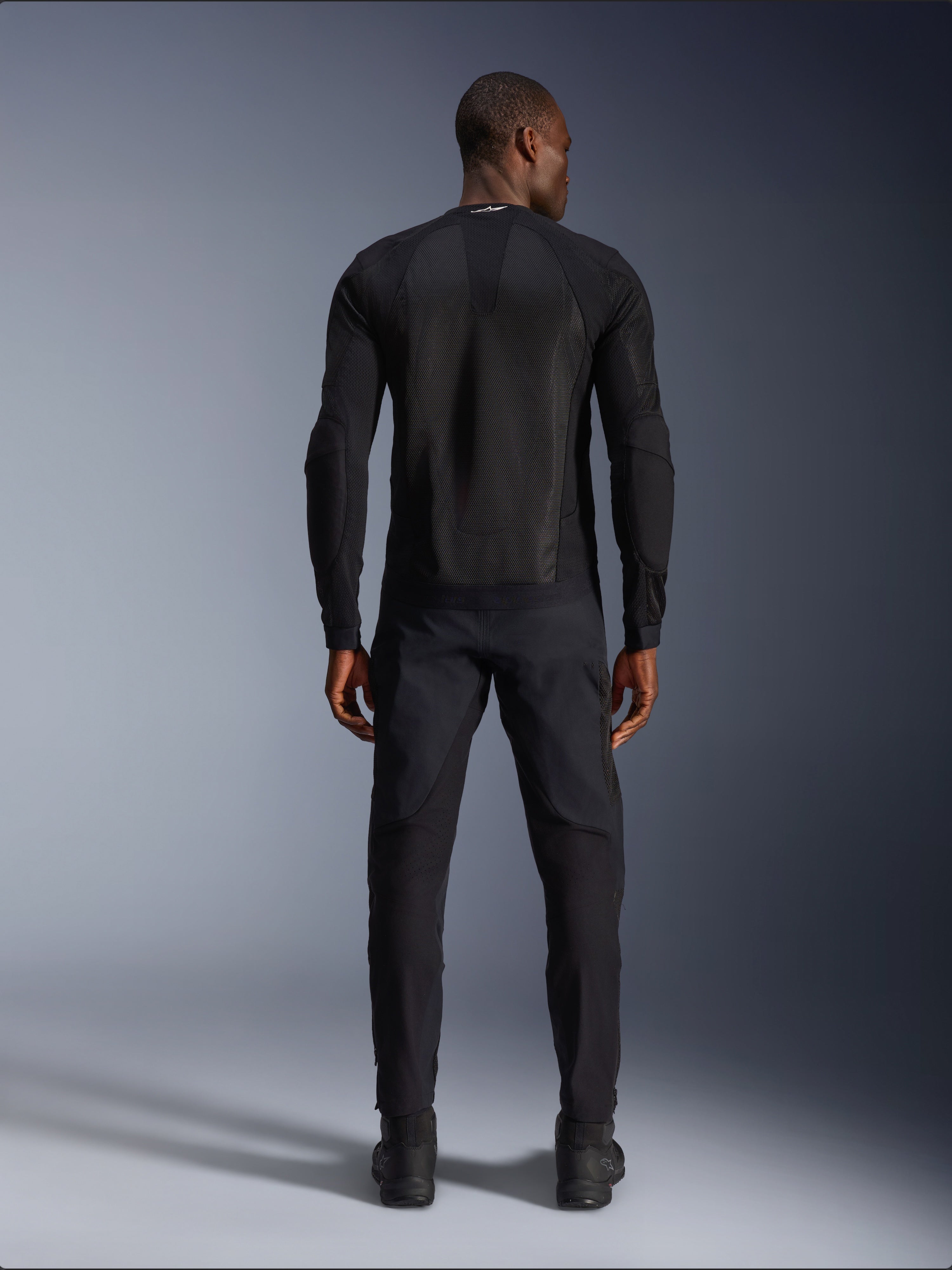 Alpinestars Troop-Air jas in Black Black, achteraanzicht met technisch mesh rugpaneel en geventileerde constructie, gecombineerd met bijpassende zwarte motorbroek en laarzen