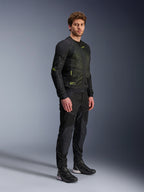 Alpinestars Troop-Air jas, mesh motorjas, zwart en fluogeel, gedragen door een model met bijpassende zwarte broek en motorschoenen, voorzien van mesh-constructie met hoge luchtstroom en fluorescerende gele accenten op de borst en mouwen, lichtgewicht technisch ontwerp voor rijden op de weg