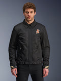 Alpinestars Ignite Air Jacket, schwarze Motorradjacke, traditioneller Hemdkragen, orange-weißes ‚A‘-Logo auf der Brust, beige gestreifte Manschetten mit weißem Stern-Logo, urbane, zeitgemäße Motorradausrüstung