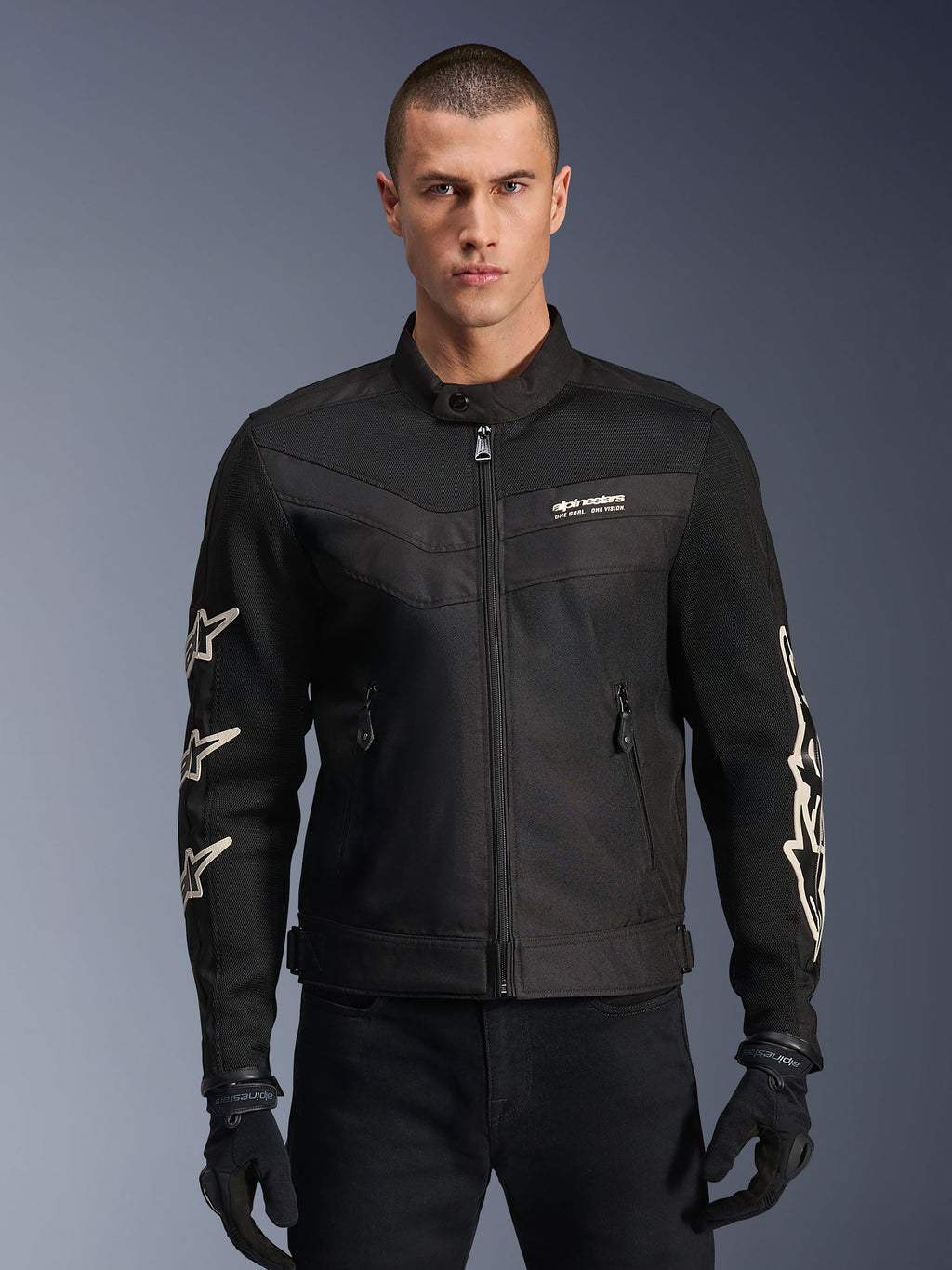 Alpinestars T-Dyno Air Jacket, veste de moto en textile noir, avec graphismes d'étoiles blanches sur les manches et logo sur la poitrine, panneaux en maille pour la ventilation, coupe de motard d'inspiration vintage, portée avec des gants et un pantalon noirs