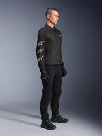 Blouson Alpinestars T-Dyno Air, noir, blouson de moto en textile, arborant trois logos Alpinestars blancs sur la manche, porté avec un pantalon et des gants noirs assortis, équipement de conduite urbaine avec panneaux en maille respirante