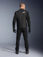 Veste Alpinestars T-Dyno Air, noire, vue arrière sur modèle, veste de moto textile dotée de panneaux en maille 3D et d'un logo étoile blanc sur l'épaule, portée avec un pantalon et des gants noirs, tenue de conduite urbaine moderne