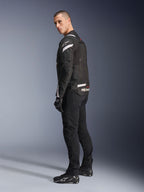 Veste Alpinestars T-Stunt Air, noir et blanc, veste de moto modulaire avec panneaux en maille technique, vue de profil arrière sur un mannequin, portée avec un pantalon de moto et des chaussures noirs, avec des accents blancs et des logos sur les épaules et le dos.