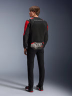 Model van achteren gezien met de Alpinestars MM93 T-SPS Air V2 Jas, zwart met felrode en witte details, voorzien van 'MARC MARQUEZ' tekst en een groot '93' logo op de onderrug, mesh textielconstructie voor ventilatie, gedragen met een zwarte broek en bijpassende zwart-rode motorschoenen