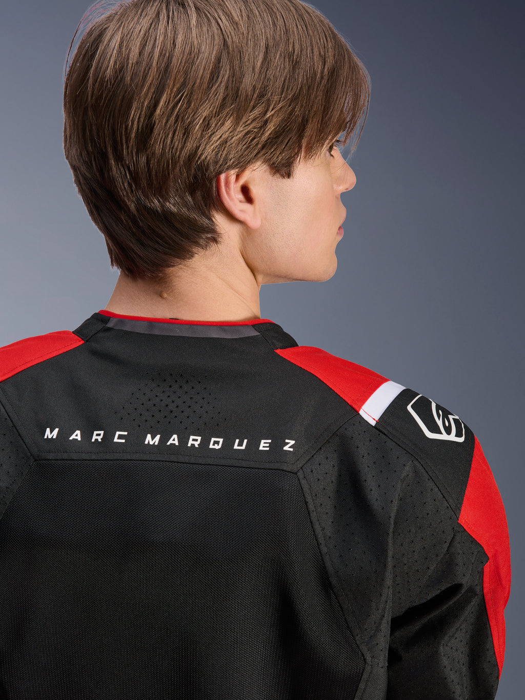 Alpinestars MM93 T-SPS Air V2 Jas, achteraanzicht van de bovenrug en schouders, zwart met felrode en witte details, 'MARC MARQUEZ' tekst op het schouderstuk, voorzien van technische mesh-panelen en schouderlogo, stedelijke sportieve motorkleding