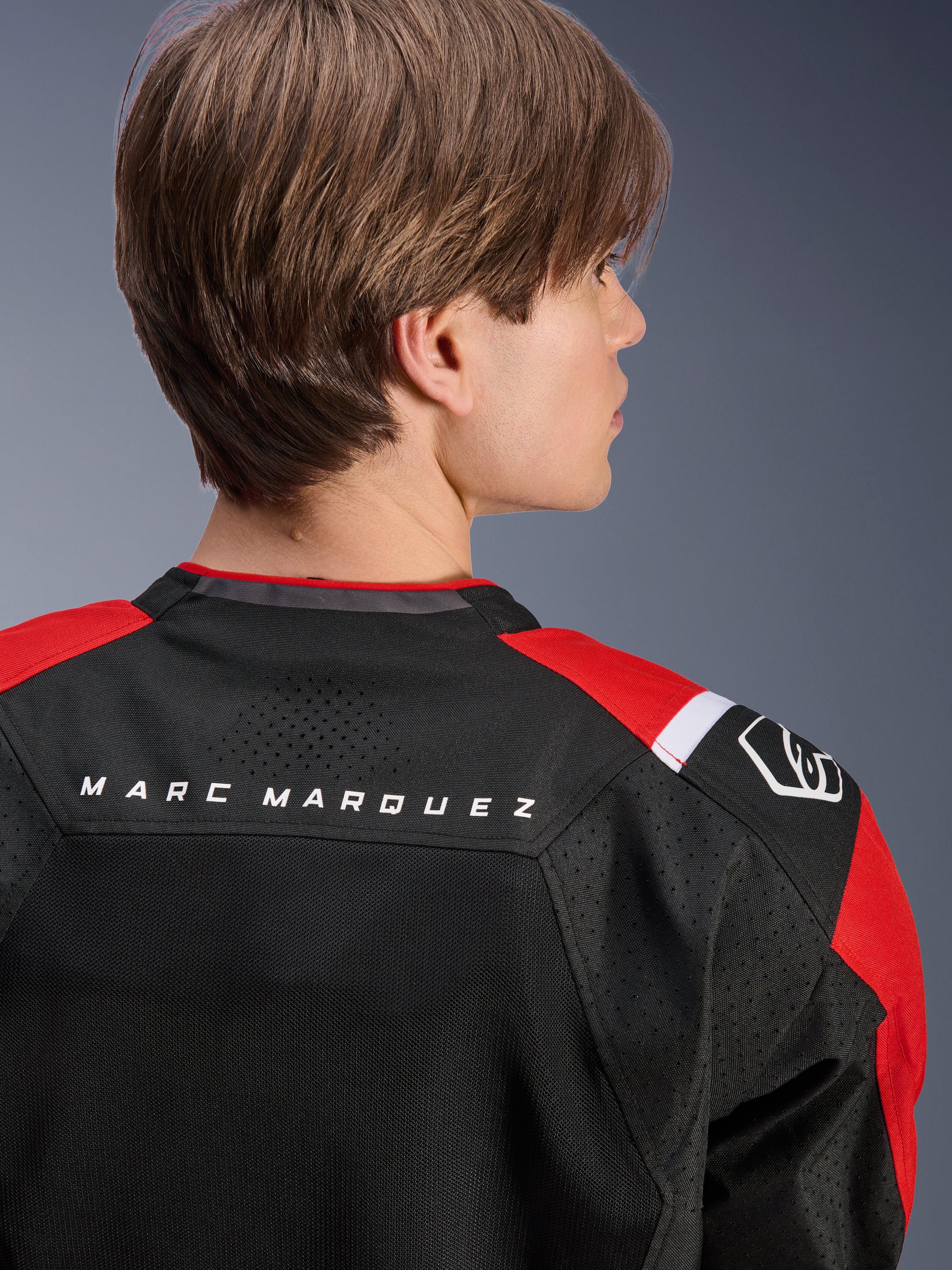 Alpinestars MM93 T-SPS Air V2 Jas, achteraanzicht van de bovenrug en schouders, zwart met felrode en witte details, 'MARC MARQUEZ' tekst op het schouderstuk, voorzien van technische mesh-panelen en schouderlogo, stedelijke sportieve motorkleding