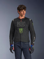 Alpinestars FQ20 T-SPS Air V2 Monster jas, zwarte motorjas met groot wit '20' cijfer en groen Monster Energy-logo, gedragen door een mannelijk model met donkere jeans en bijpassende handschoenen, lichtgewicht mesh-constructie voor stedelijk rijden