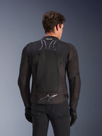 Veste Alpinestars SMX Air en Black Anthracite, vue de dos sur un mannequin, dotée d'un grand panneau dorsal en maille technique pour la ventilation, marquage Tech-Air Ready sur le col et logo Astar argenté dans le bas du dos, portée avec des gants noirs et un pantalon de moto.