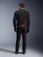 Veste Alpinestars SMX Air, noire avec logo rouge vif, vue arrière montrant le marquage Tech-Air Ready et les panneaux de ventilation en maille, portée avec un pantalon et des gants noirs, équipement de moto de sport et de course haute performance