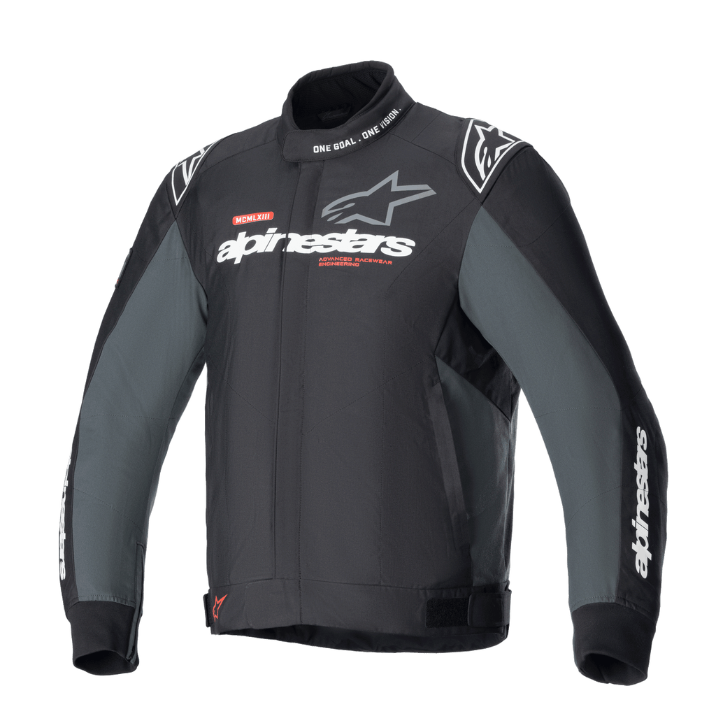Alpinestars Monza Sport Jacket, Black Tar Gray textiel motorjas, hoge kraag met 'ONE GOAL. ONE VISION.' tekst, witte en grijze Alpinestars-logo's op de borst, sterlogo's op de schouders, rode grafische accenten, verstelbare tailleverstellers, strak technisch design