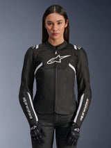 Veste Alpinestars Stella T-Sps Air V2 pour femme, veste de moto en textile noir et blanc, dotée de panneaux en mesh perforés et d'accents de logo blancs, portée avec des gants noirs, conçue pour la conduite sur route en été.