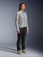 Femme portant la veste Alpinestars Stella C-1 Air en Silver, veste de moto légère en textile et maille, associée à un pantalon de moto noir et des baskets décontractées, esthétique de conduite urbaine épurée.