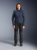 Modèle femme portant la veste Alpinestars Stella C-1 Air en bleu, veste de moto urbaine avec panneaux en maille technique, associée à un pantalon de moto noir et des baskets noires, vue de face en studio