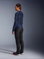 Femme portant la veste Alpinestars Stella C-1 Air en bleu, vue de trois-quarts arrière, mettant en évidence les panneaux arrière en mesh et les pattes de réglage à la taille, associée à un pantalon de moto noir et des baskets noires, vêtements de moto urbains