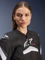 Alpinestars Stella T-GP Plus R V4 Jacket, Women's Textile Motorcycle Jacket, Black and White with grey accents and pink 'T-GP PLUS' text, close-up view of female model wearing the sport-fit jacket with white Astars logos