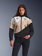 Alpinestars Stella Moshell Jacket, urban motorjas voor dames, asymmetrisch kleurgeblokt ontwerp in zwart, zand en off-white, voorzien van ritssluiting aan de voorzijde en steekzakken met rits, gedragen met een zwarte broek voor een eigentijdse streetwear-look.