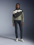 Alpinestars Stella Moshell motorjas, dames motorjas, zwart, grijs en gebroken wit met roze accenten, gedragen door een model met een donkere jeans en gebroken witte sneakers, voorzien van een asymmetrisch ritsontwerp met opvallende geometrische graphics, eigentijdse urban motoruitrusting