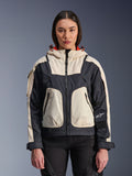 Alpinestars Molly Air Jacket, urban motorjas voor dames, Black Almond, vooraanzicht op een model, voorzien van crème en zwarte ripstop-panelen, capuchon met oranje voering, ritssluiting aan de voorzijde en grote utility-zakken, eigentijdse op streetwear geïnspireerde motorkleding