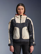 Alpinestars Molly Air Jacket, urban motorjas voor dames, Black Almond, vooraanzicht op een model, voorzien van crème en zwarte ripstop-panelen, capuchon met oranje voering, ritssluiting aan de voorzijde en grote utility-zakken, eigentijdse op streetwear geïnspireerde motorkleding