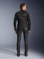 Alpinestars Stella T-Dyno Air Jacke, Rückansicht, schwarze Damen-Motorradjacke mit weißer Paspelierung und kleinem Stern-Logo, getragen mit schwarzer technischer Hose und Motorradstiefeln, schmale Biker-Passform für urbane Fahrten