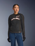 Femme portant la veste Alpinestars Stella SMX Air, noir, blanc et rouge fluo, veste de moto en textile avec maille ventilée et logo blanc sur la poitrine, associée à un jean bleu et des gants de moto noirs, coupe féminine pour la conduite sportive