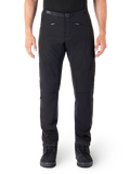 Pantalon Alpinestars Alden, pantalon de moto urbain noir, vue de face, tissu softshell technique extensible, ceinture intégrée avec boucle magnétique, poches avant zippées, détails matelassés aux genoux, silhouette ajustée, porté avec des chaussures de moto noires