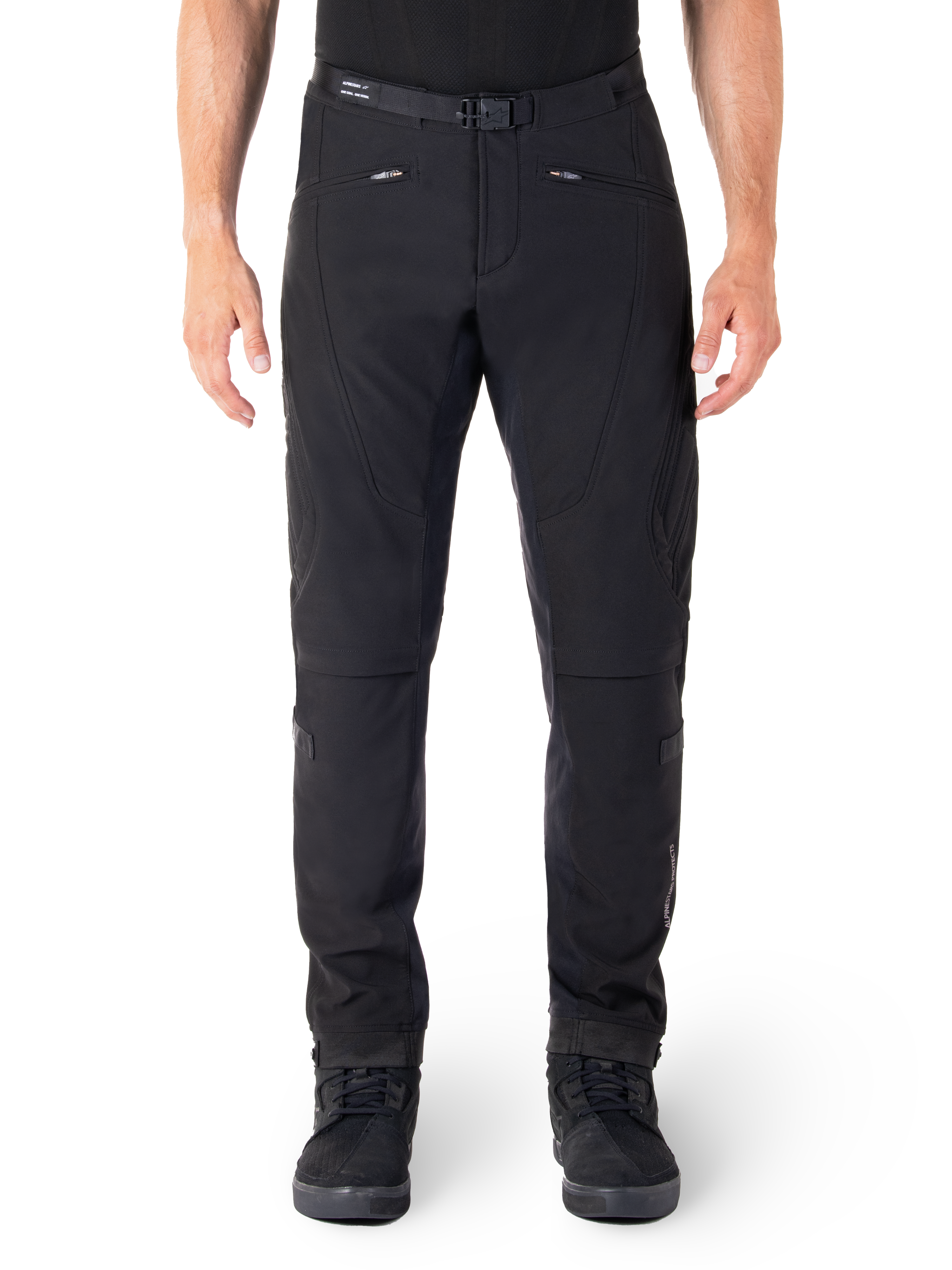 Alpinestars Alden Hose, Schwarze Urban-Motorradhose, Vorderansicht, technisches Stretch-Softshell-Gewebe, integrierter Gürtel mit Magnetschnalle, Reißverschlusstaschen vorne, gesteppte Knie-Details, Slim-Fit-Silhouette, kombiniert mit schwarzen Motorradschuhen