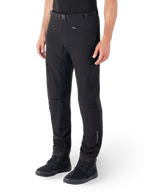 Pantalon Alpinestars Alden, pantalon de moto urbain, noir, tissu softshell technique avec coupe régulière, doté d'une boucle de taille magnétique, d'empiècements latéraux matelassés, de poches zippées et d'un logo discret sur le bas de la jambe, porté avec des chaussures de moto noires