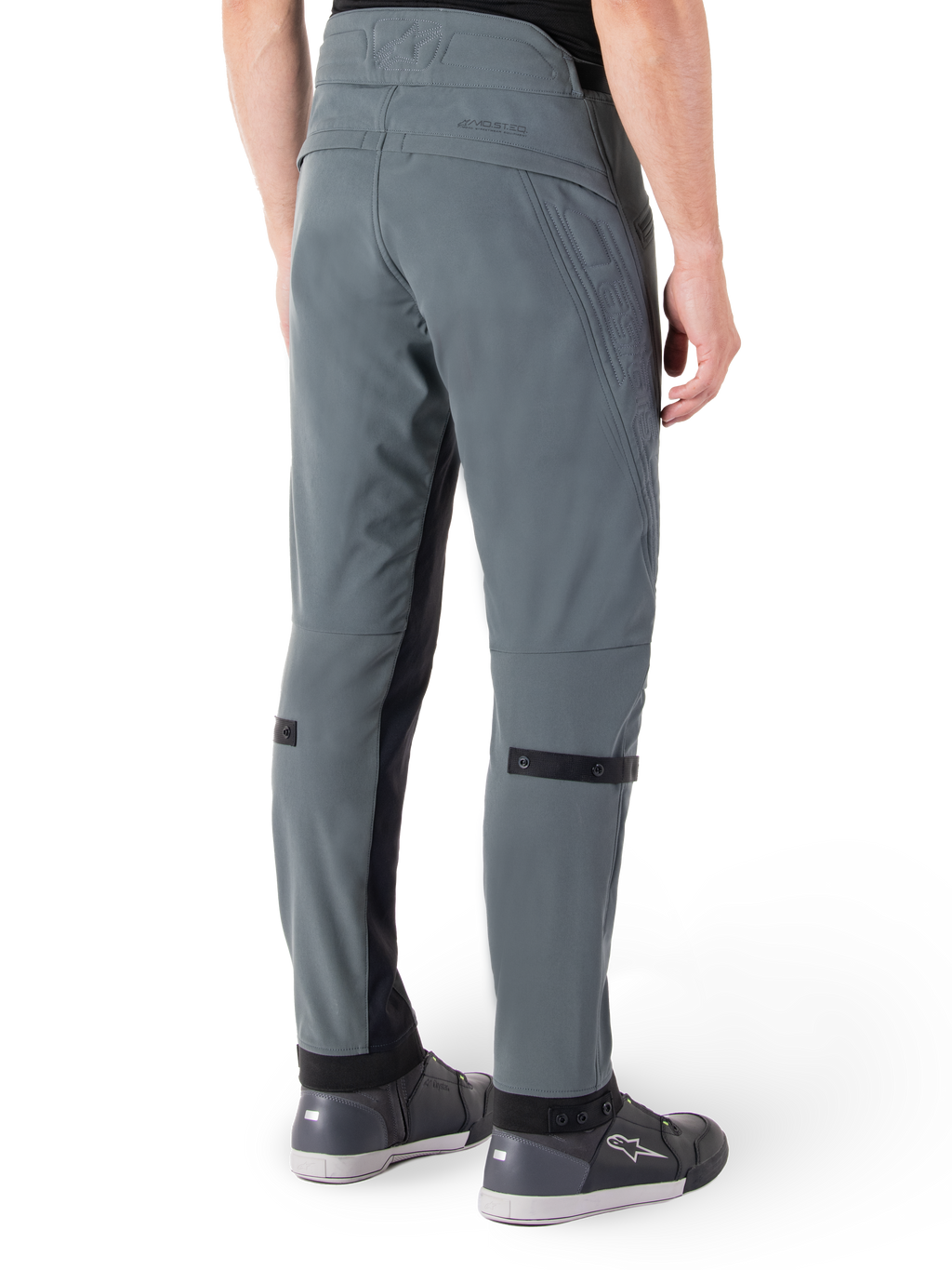 Alpinestars Alden broek, Urban Gray, achteraanzicht, op streetwear geïnspireerde technische motorbroek met gewatteerde details in de taille en zwarte kuitbanden, gecombineerd met grijze motorschoenen, moderne stedelijke motoruitrusting
