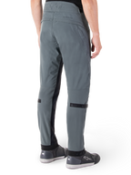 Alpinestars Alden broek, Urban Gray, achteraanzicht, op streetwear geïnspireerde technische motorbroek met gewatteerde details in de taille en zwarte kuitbanden, gecombineerd met grijze motorschoenen, moderne stedelijke motoruitrusting