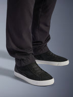 Alpinestars Flex-AST Cargo Broek - Short, stedelijke motorbroek, zwart, voorzien van taps toelopende pijpen met elastische zomen, gecombineerd met zwarte Alpinestars sneakers, eigentijdse urban rijstijl