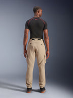 Alpinestars Flex-AST Cargo Pants, lichtbeige, achteraanzicht op een model, regular tapered pasvorm met cargozakken aan de zijkant en elastische zomen, gecombineerd met een zwarte basislaag met korte mouwen en rode accenten, stedelijke motorkleding