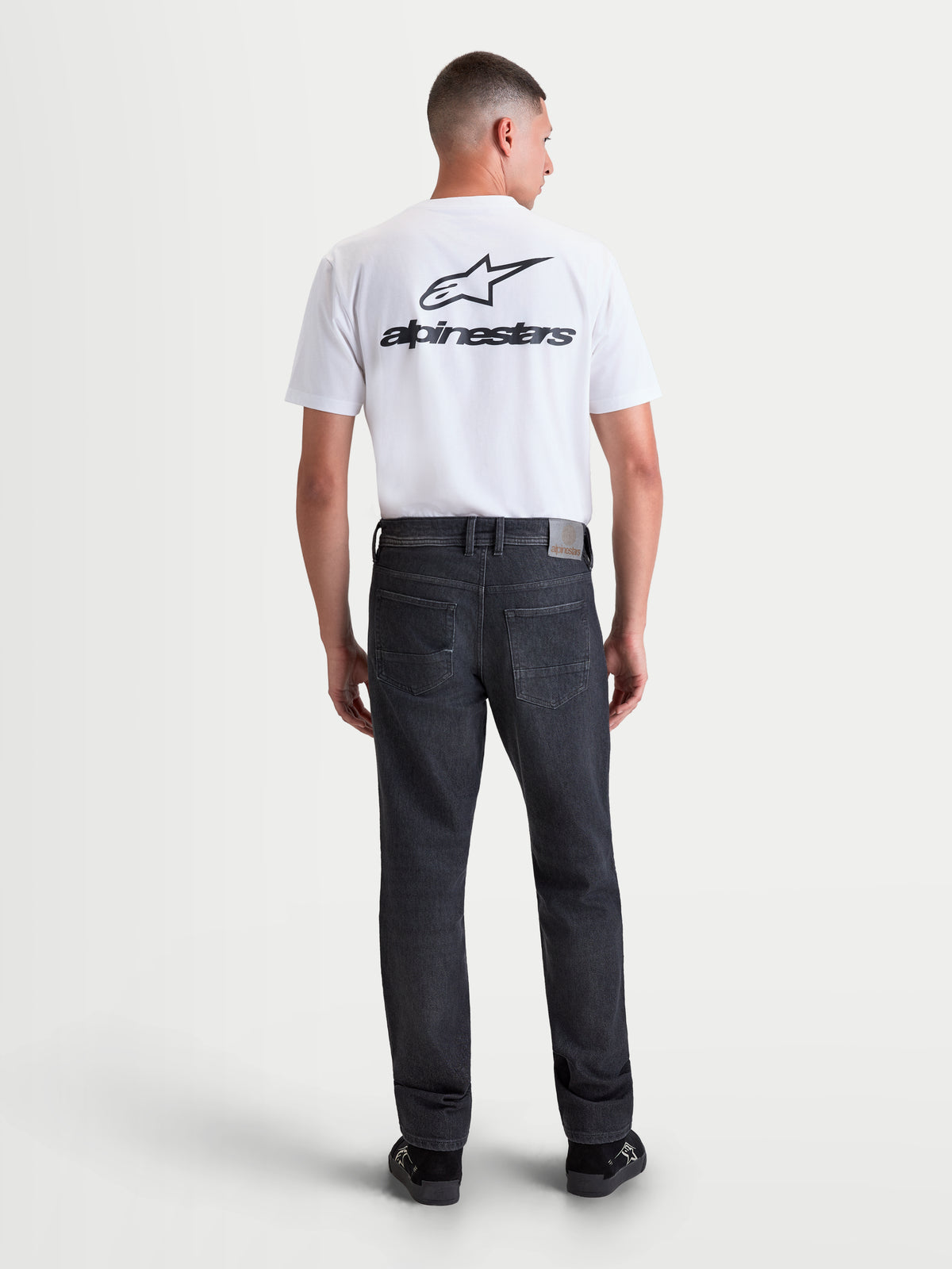 Alpinestars Flex-AST 8 Denim Pants Short, pantalon de moto urbain pour homme noir usé, vue de dos montrant la construction en denim technique monocouche, le design à cinq poches et la coupe droite porté par un modèle
