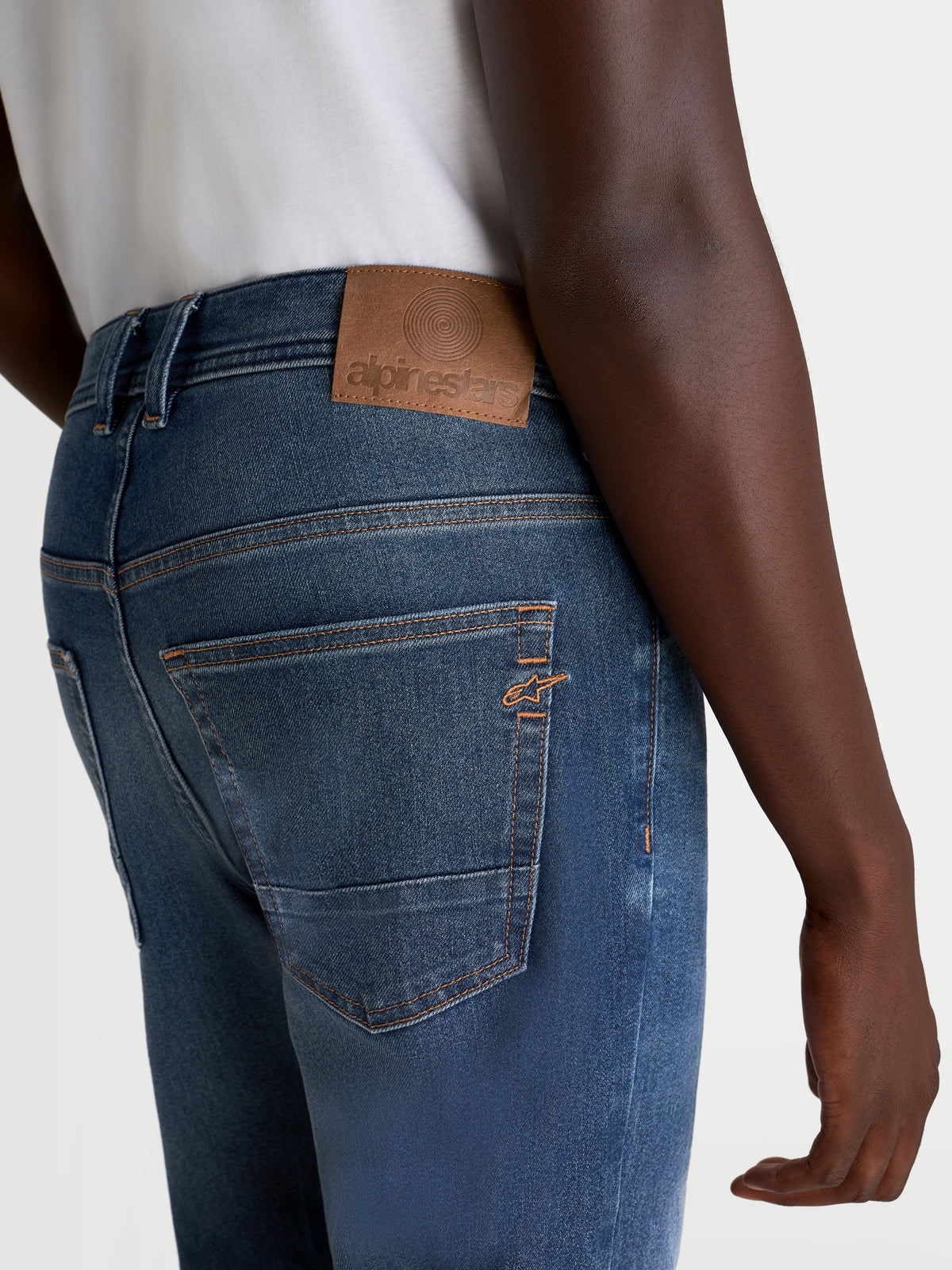 Alpinestars Flex Ast 8 Denim broek, urban motorjeans voor heren in medium blauw, achteraanzicht met leren rugpatch, contrasterende stiksels en geborduurd Astar-logo op de zak gedragen door een model