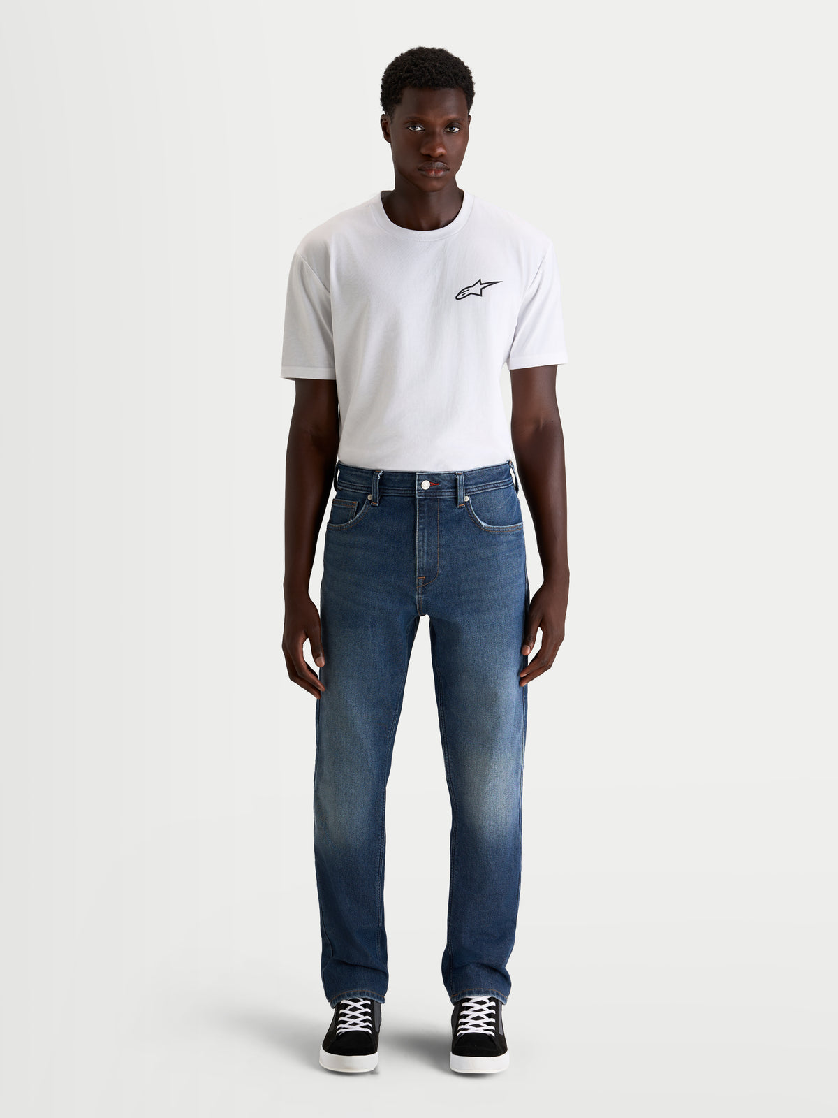 Alpinestars Flex Ast 8 Denim broek, urban motorjeans voor heren in middenthermisch blauw, straight-fit enkellaags technische denim gedragen door een model met een wit t-shirt, AA-gecertificeerde bescherming