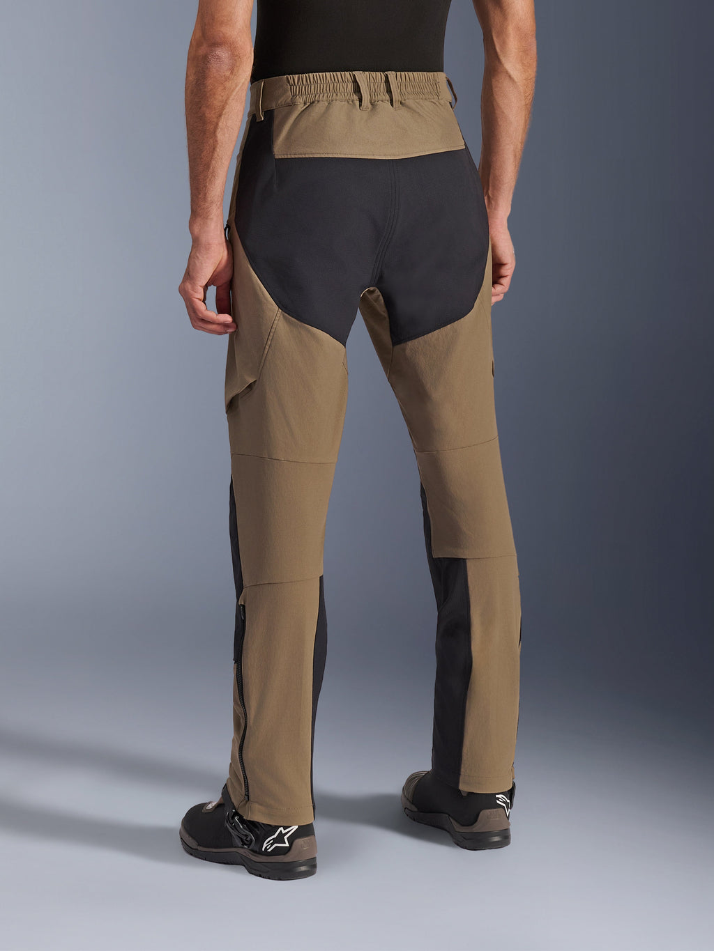 Alpinestars Flex-AST Explorer Hose, Adventure-Motorradhose in Walnut Black, Rückansicht mit schwarzen Ripstop-Einsätzen an Gesäß und Beinen, elastischem Hosenbund und strapazierfähiger Stretch-Textilkonstruktion.