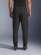 Alpinestars Aeroshell Airflow Pants, Black, rear view, featuring laser-perforated zones on the calves and mesh paneling, worn with black Alpinestars boots, lightweight softshell design for sport and touring