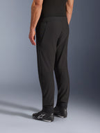 Alpinestars Aeroshell Airflow Pants, Black Motorcycle Pants, three-quarter rear view, lightweight stretch softshell construction with integrated mesh panels, adjustable ankle cuffs, worn with black Alpinestars riding shoes