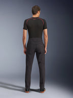 Alpinestars Flex-AST Canvas Pants, urban motorbroek, zwart, achteraanzicht met op werkkleding geïnspireerd ontwerp, achterzakken en verlengde rugstijging, gedragen met een zwarte basislaag en sneakers, ergonomische rijpasvorm