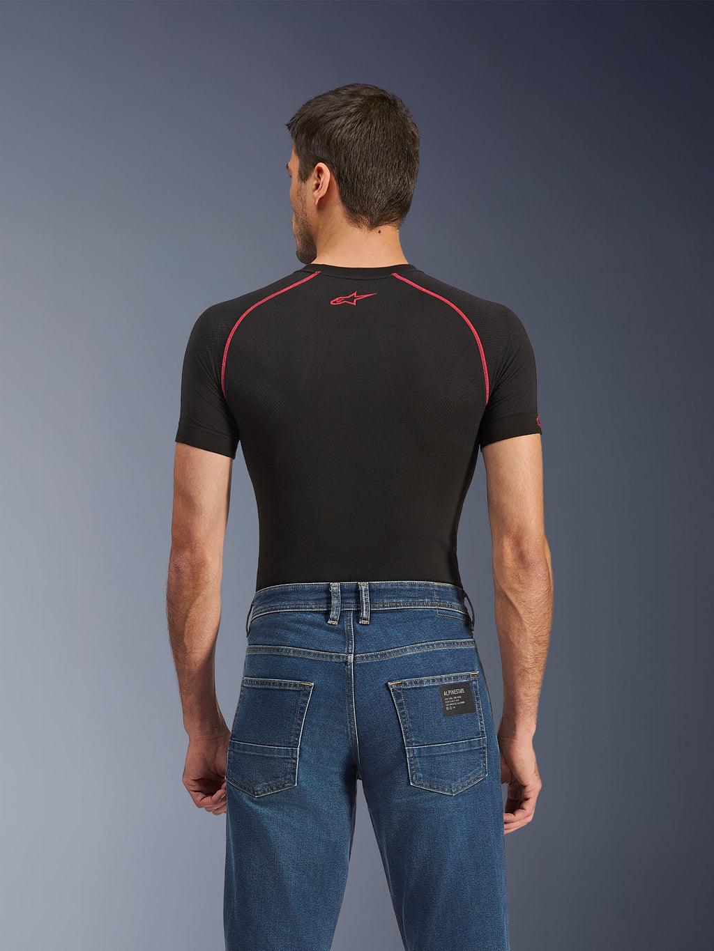 Alpinestars Flex-AST 5 Denim Pants, Indigo Washed, achteraanzicht met regular tapered fit, gedragen met zwarte basislaag met korte mouwen en rode stiksels, casual stedelijke motorjeans