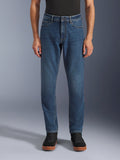 Alpinestars Flex-AST 5 Denim Broek, urban motorjeans, Indigo Washed blauw, vooraanzicht met een moderne toelopende pasvorm en casual five-pocket styling, gedragen met een zwarte top en sneakers, ontworpen voor stedelijk rijcomfort en bescherming.