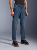 Alpinestars Flex-AST 5 Denim Pants, Indigo Washed motorjeans, regular tapered fit, gedragen met zwarte high-top sneakers en een zwart shirt, casual urban motorkleding met een klassieke denim uitstraling.