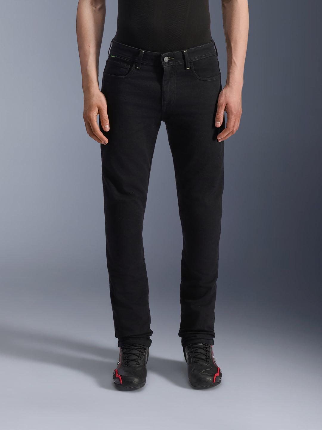 Alpinestars Copper V3 Denim Pants, Black Rinse motorjeans, regular comfort pasvorm met rechte pijpen, met voorzakken en riemlussen, getoond op een model met zwart-rode sneakers, hoogwaardige motorjeans voor stedelijk woon-werkverkeer
