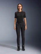Alpinestars Alamosa damesbroek, slim-fit zwarte motorbroek, getoond op een model van voren, met ritszakken aan de voorkant en een geïntegreerde tailleriem, minimalistische op streetwear geïnspireerde stijl voor stedelijk rijden