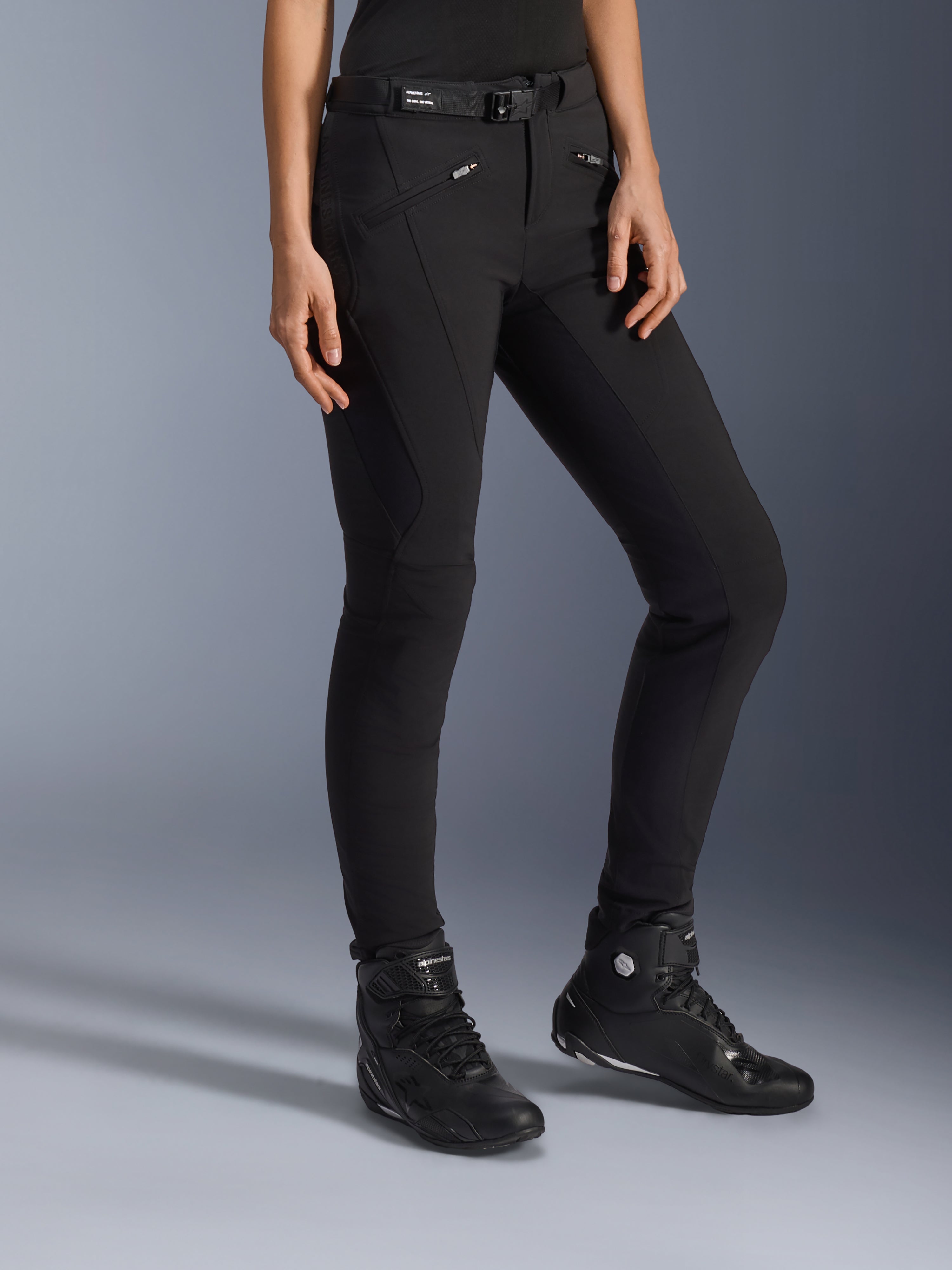 Alpinestars Alamosa Women Pants, zwarte urban motorbroek, slim-fit ontwerp met ritszakken en geïntegreerde tailleriem, gecombineerd met zwarte hoge motorschoenen
